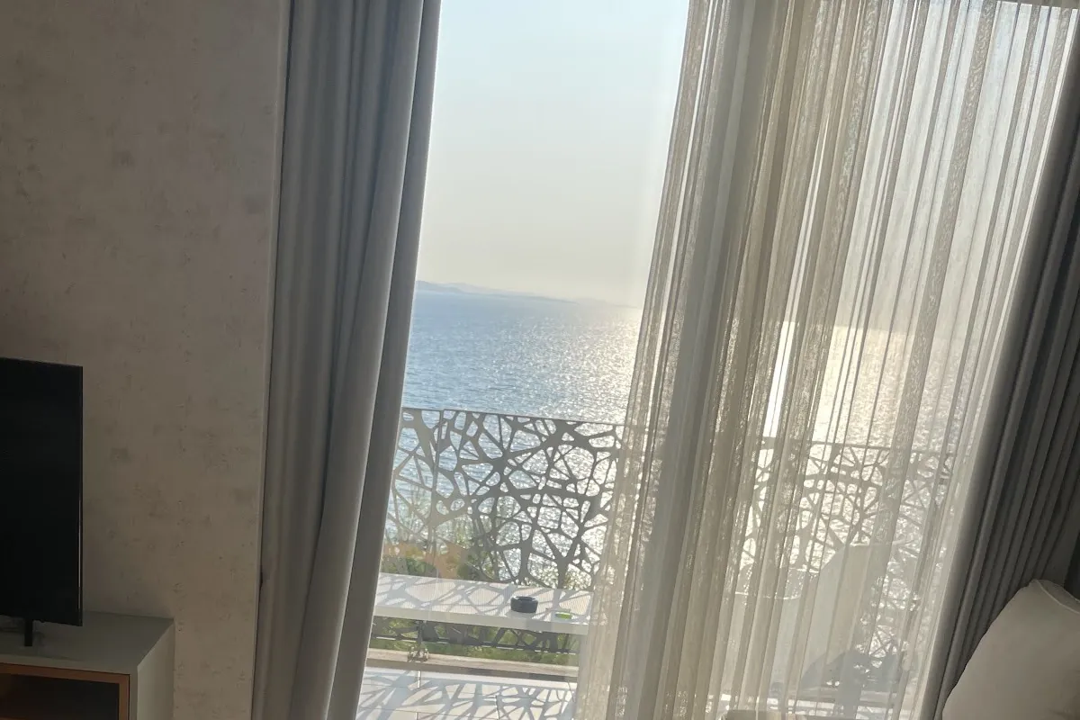 Sunlit apartment with a massage bed and an open door to a sea-view balcony