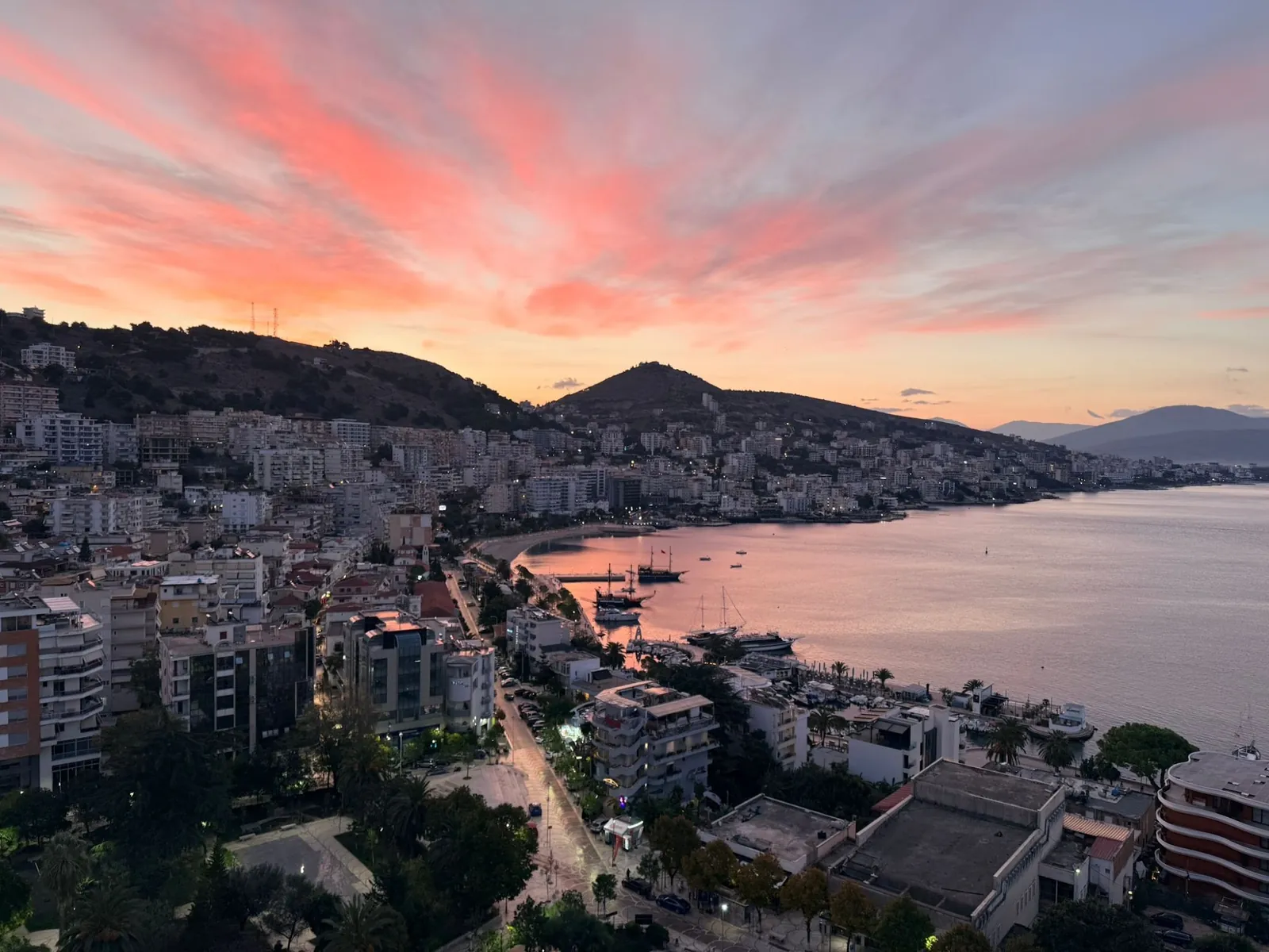 Sarandë bay at sunset, boats in the harbour