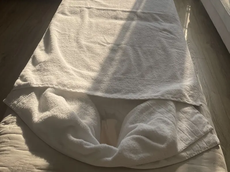 Folded white towels on the massage bed